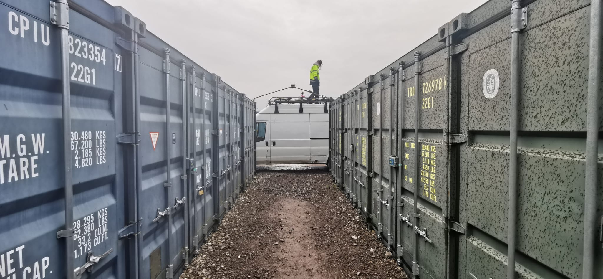 Meet Joe, your trusted Bristol removals expert. Joe stands at the end of our van, flanked by shipping containers, ready to provide top-notch removals near you.